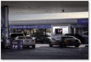 Digital advertising display showcasing a Samsung campaign at an ADNOC gas station in Abu Dhabi, UAE.