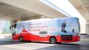 Large format vinyl vehicle wrap on a city commuter bus showcasing a premium cultural art exhibition campaign