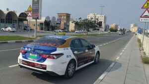 Full rear window and side door wrap campaign on an official RAKTA public taxi for transit advertising in Ras Al Khaimah