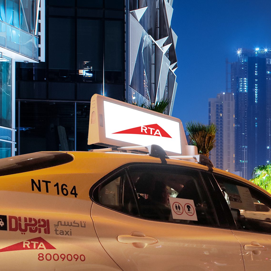 Premium digital rooftop taxi advertising screen displaying high-brightness campaigns on a Dubai RTA cab at night