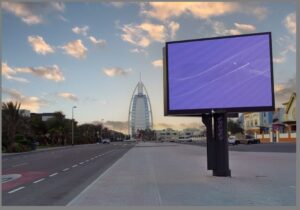 Digital billboard display situated on a street with Burj Al Arab in the background