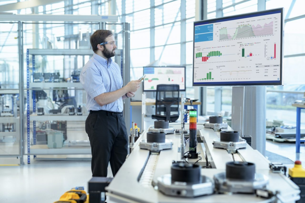 engineer testing a robotic production simulator in robotics research facility