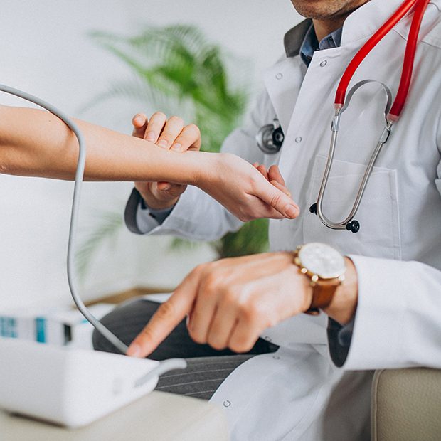 Doctor checking patient pulse and blood pressure during medical checkup