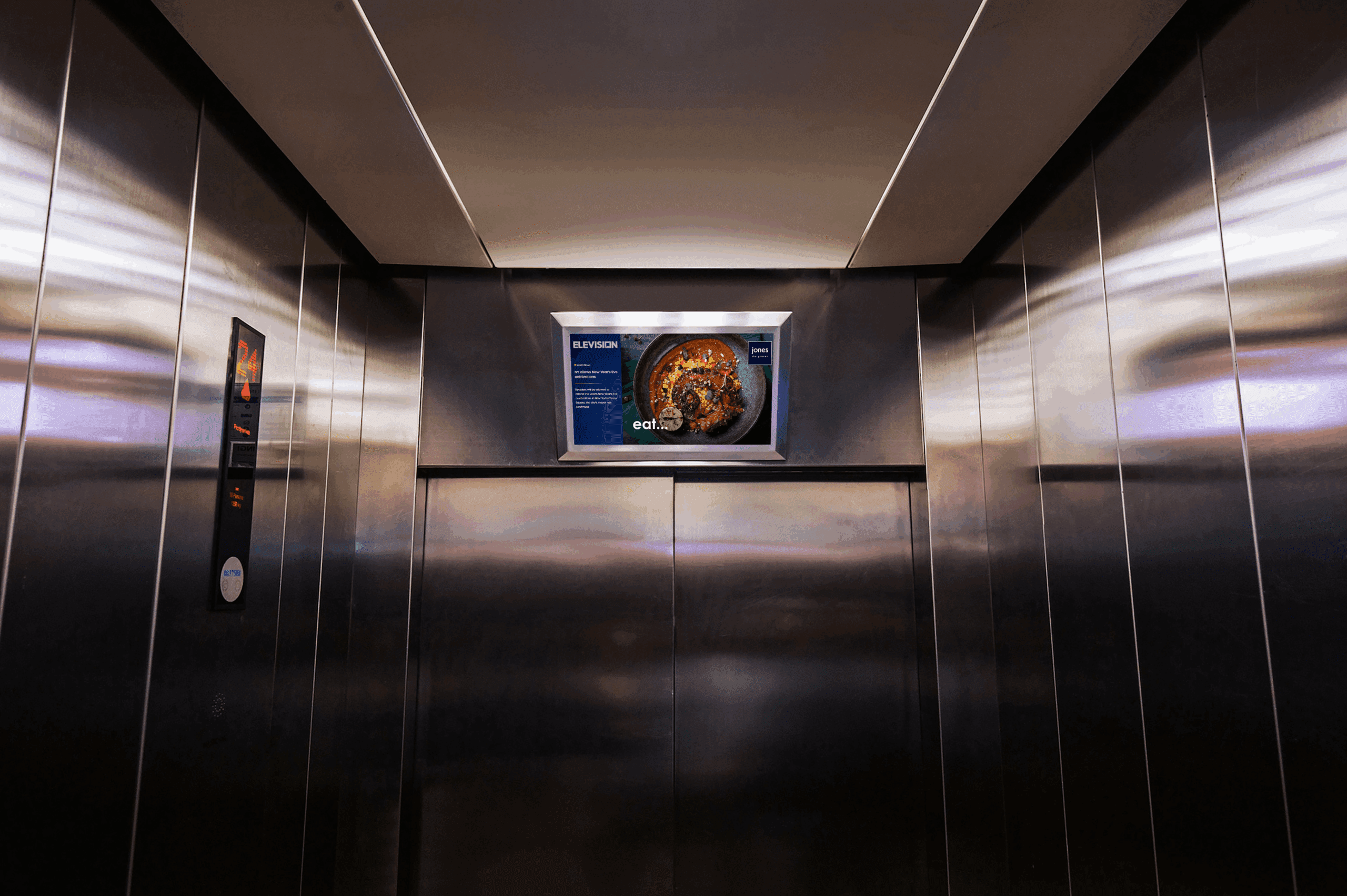 Digital advertising screen mounted inside a premium stainless-steel elevator for captive audience marketing in Dubai