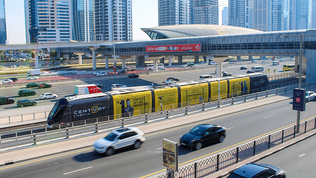 Century Financial branded tram traveling on Dubai highway track