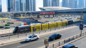 Century Financial branded tram traveling on Dubai highway track