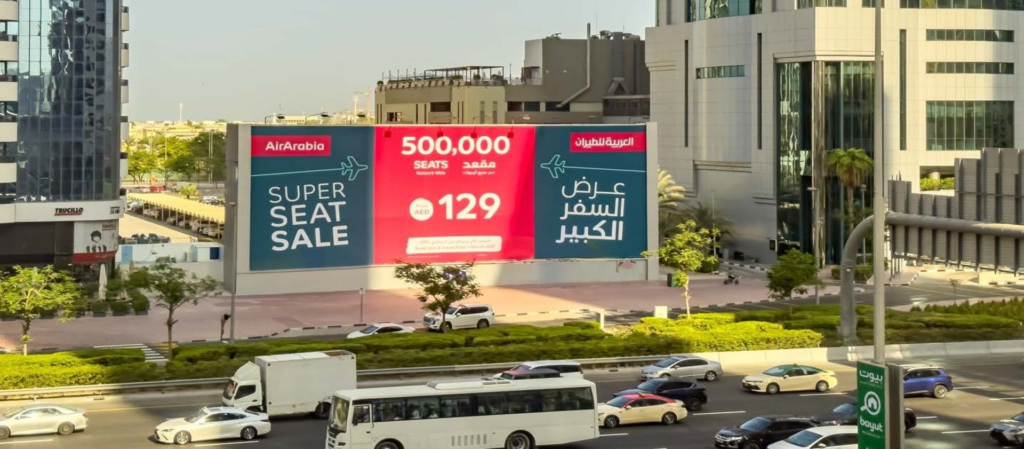Air Arabia 'Super Seat Sale' hoarding billboard advertisement displayed along Sheikh Zayed Road in Dubai.