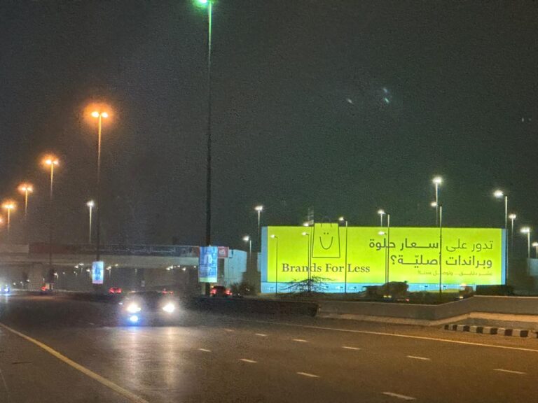 Large-format roadside hoarding advertisement for Brands For Less in Ras Al Khaimah, UAE at night