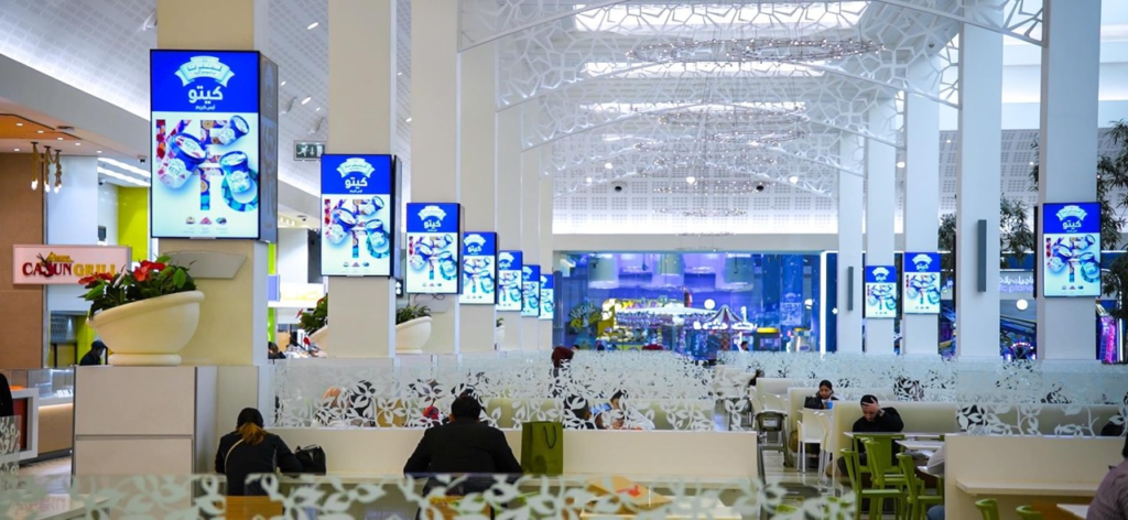 Series of LED digital screens installed on mall pillars displaying promotional advertising for retail brands