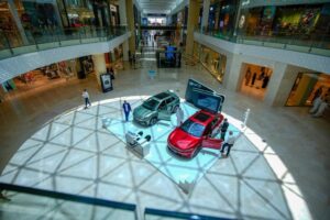 BYD automotive brand activation and vehicle display featuring new electric car models in the central atrium of Yas Mall, Abu Dhabi