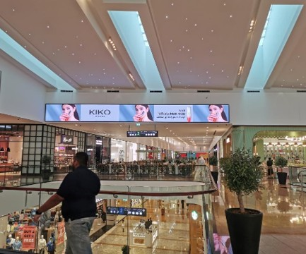 High-impact horizontal LED display used for premium retail brand marketing within a busy commercial shopping center